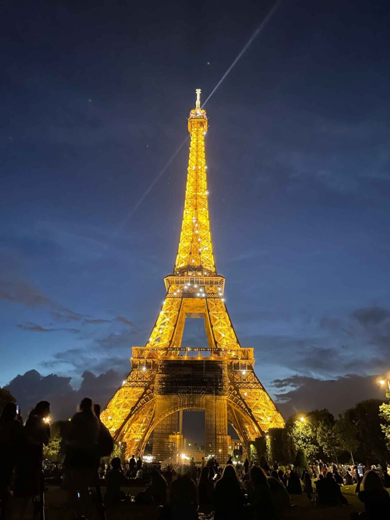 Picnicking in front of the Eiffel Tower is one of the best things to do in Paris at night.